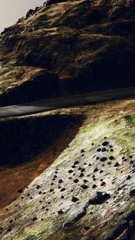 a winding road leads through a mountain pass.