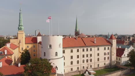 Exterior-of-Riga-Castle-on-banks-of-River-Daugava,-Riga,-Latvia,-aerial-rising