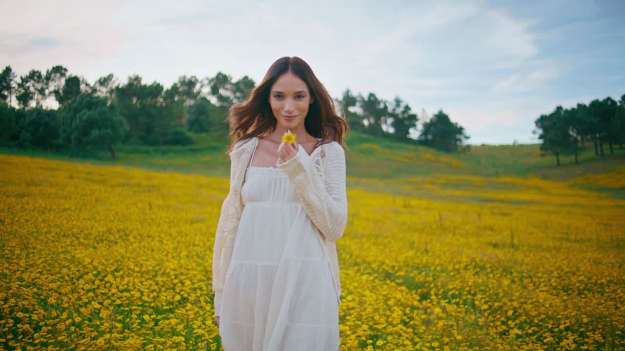 Brunette enjoy walk meadow at summer. Girl strolling at yellow flowers field
