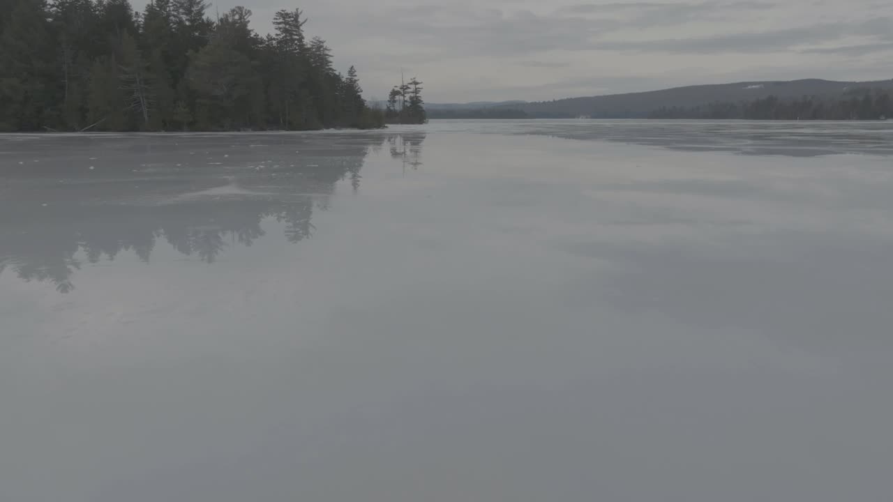 Spectacular low aerial over frozen Lake Hebron reflective view