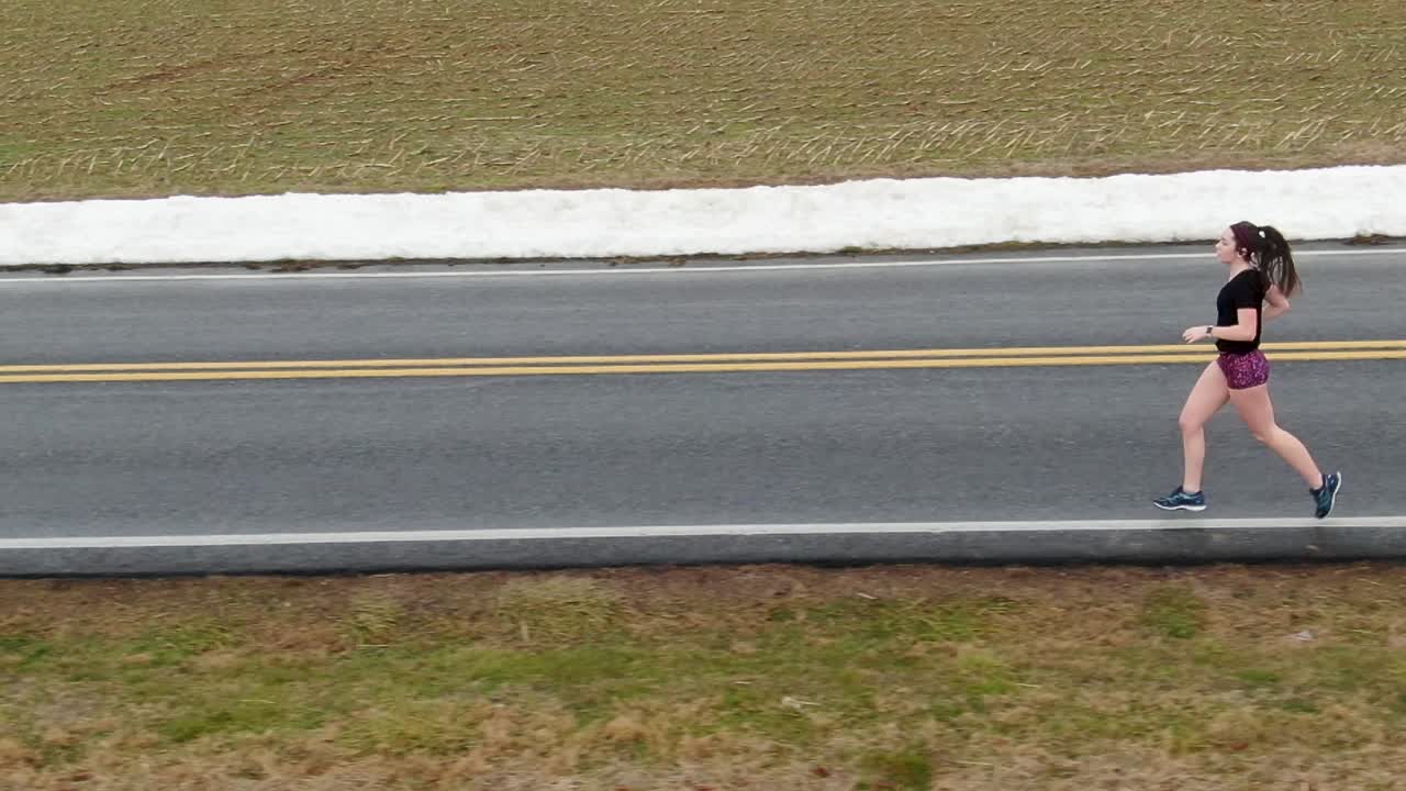 Slow-motion side profile shot of a teenage female runner, athletic training, sport, exercise, weight loss, diet theme