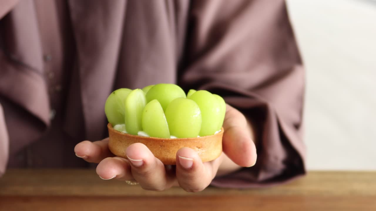 mujer decorando una deliciosa tarta de uva