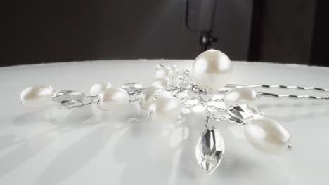 elegant white pearls and faceted clear crystals necklace on a reflective surface