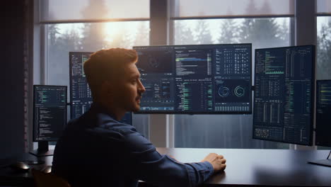 professional developer working on multi-monitor setup with code and data