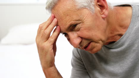 worrier mature man sitting on bed