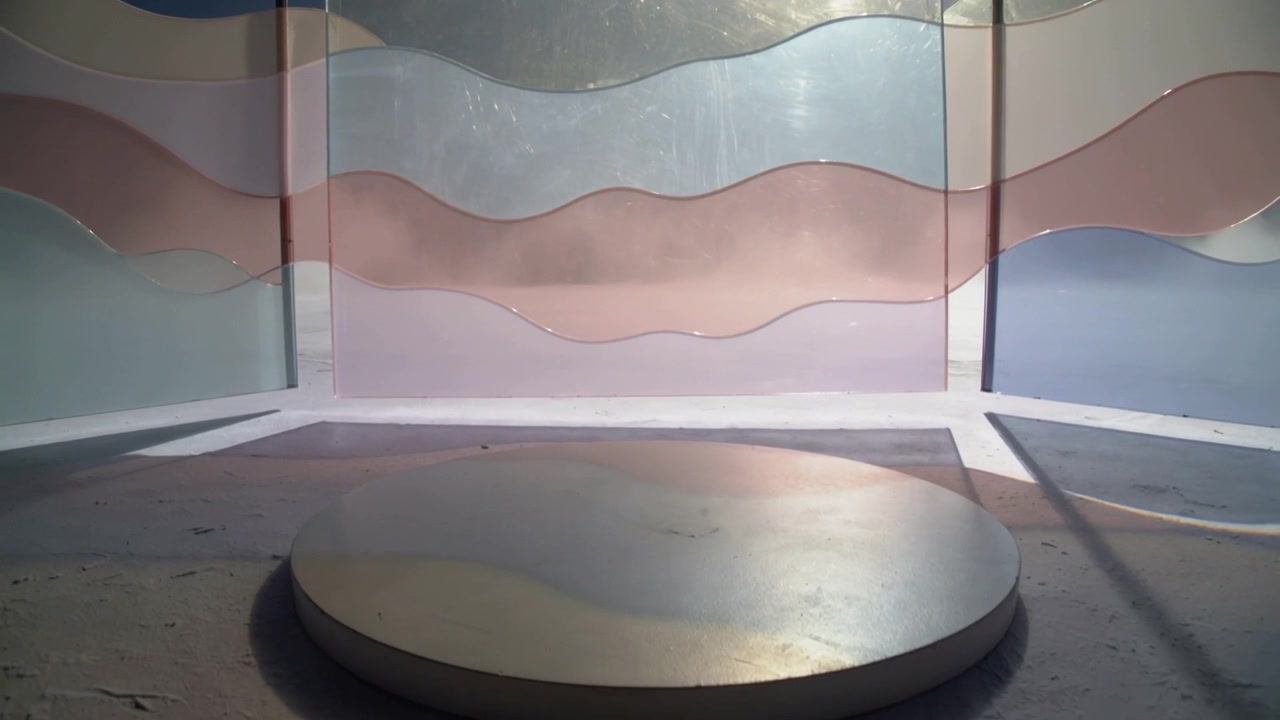 Shifting sunlight revealing translucent pastel wavy panels in showroom, showing circular pedestal