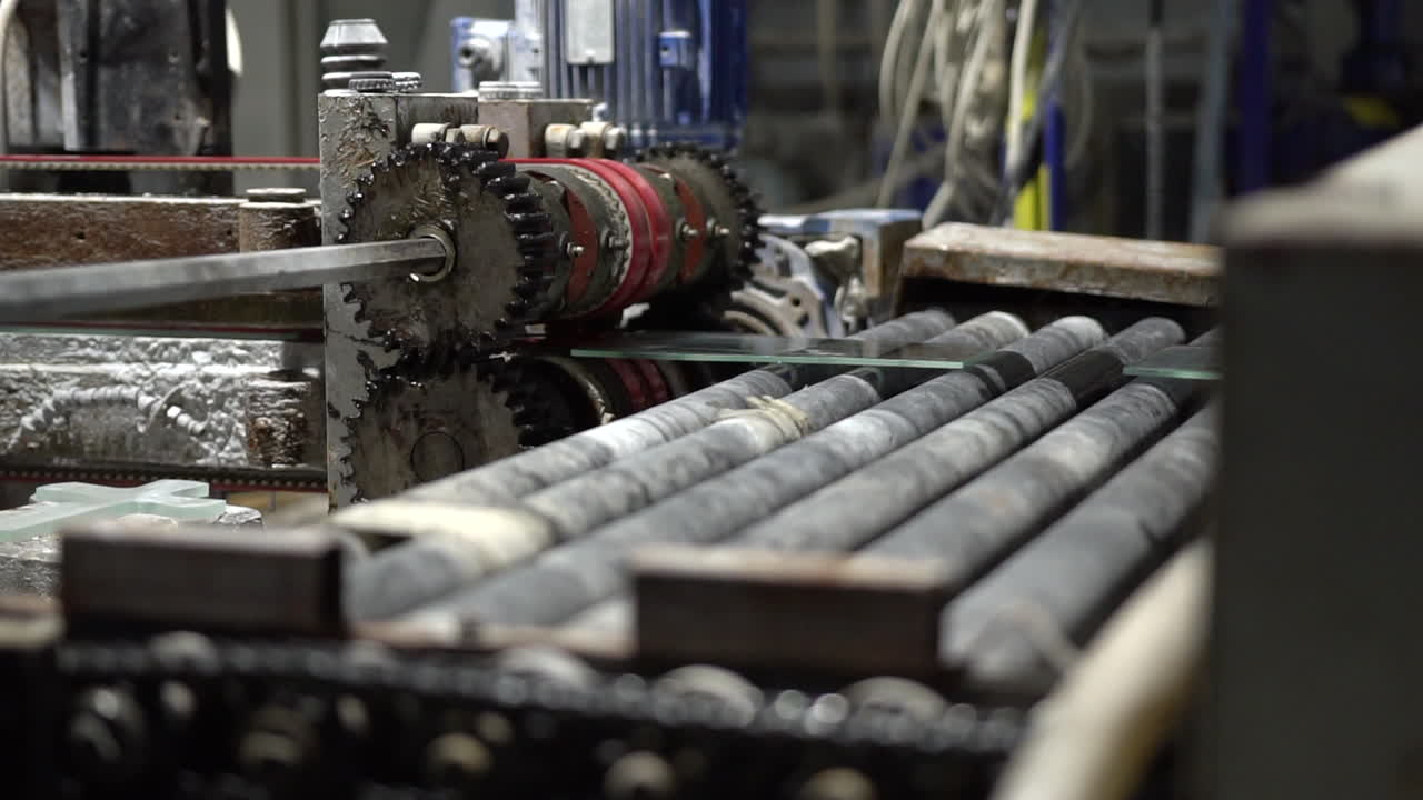 슬로모션으로 유리 공장의 전송 롤러에서 라인을 따라 움직이는 유리 패널