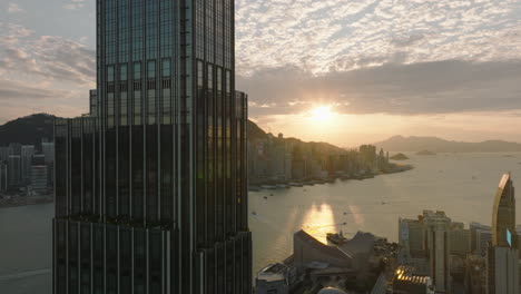 cinematic view of rosewood hotel facing west towards hong kong island during sunset