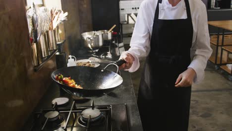 chef cocinando verduras con fuego