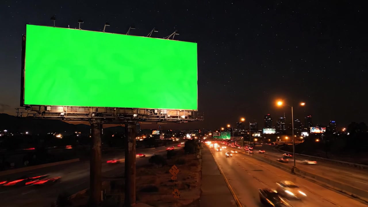 Reklametavle viser tom grøn plads med byens skyline i baggrunden på forskellige tidspunkter af dagen langs en travl motorvej.