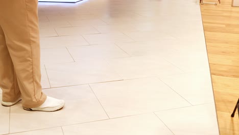 person cleaning floor with a mop