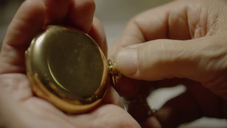 a person twists a dial on a pocket watch