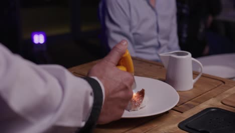 in a restaurant setting, a chef provides table-side service, searing japanese a5 wagyu beef atop sushi