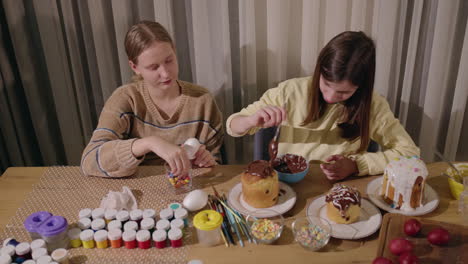 hermanas decorando pan y huevos de pascua