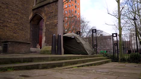 tent of a homeless person in london, next to a church and a park, homelessness problems in the united kingdom