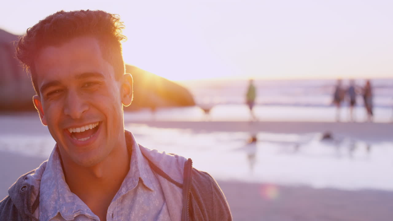Homem Sorrindo na Praia ao Pôr do Sol