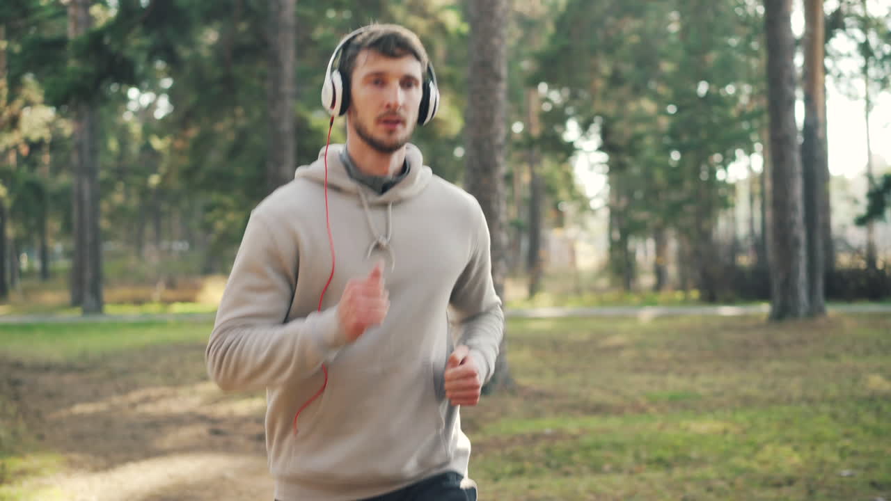 헤드폰을 들고 공원에서 달리는 남자