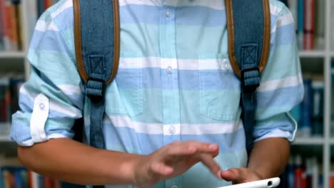 Portrait-of-happy-schoolboy-using-digital-tablet-in-library