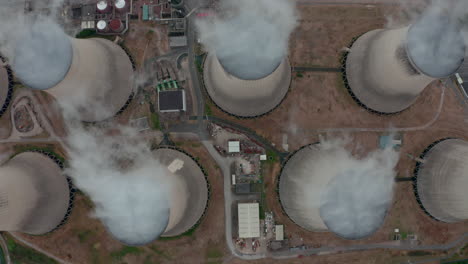 top down slider drone shot of large power plant cooling towers from above