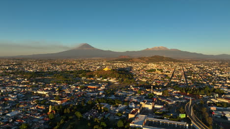 drone haciendo zoom en la iglesia y la pirámide de cholula, hora de oro en puebla, méxico