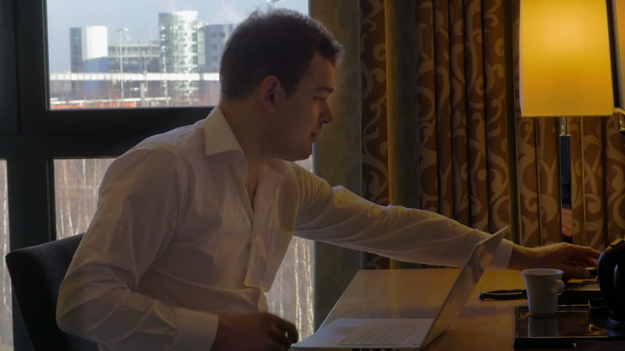 joven empresario trabajando con una computadora portátil y recibiendo llamadas