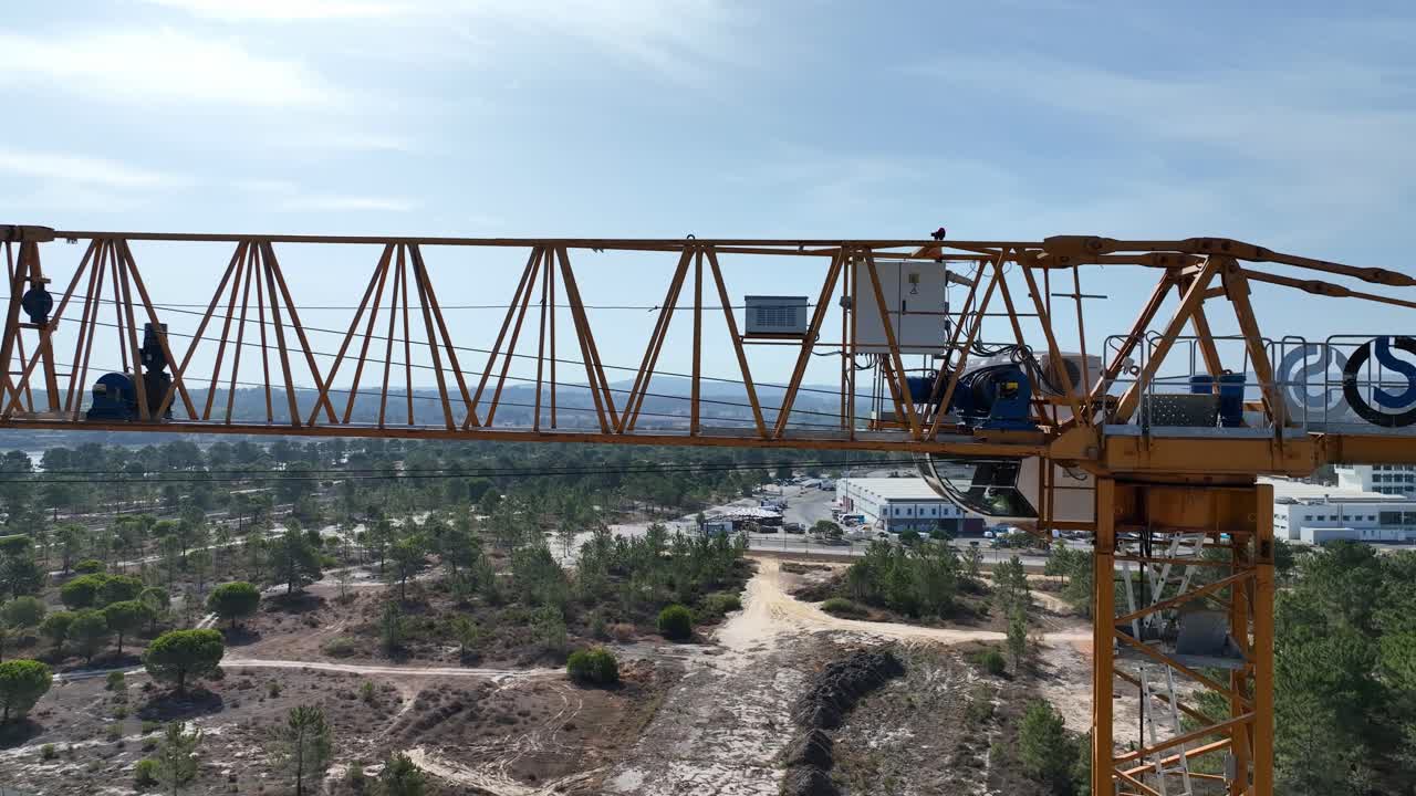 drone disparado volando lateralmente filmando una grúa de construcción de cerca