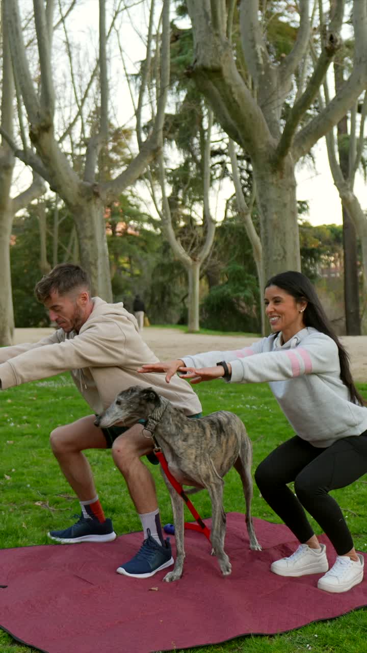 Pareja haciendo ejercicio con su perro en un parque verde