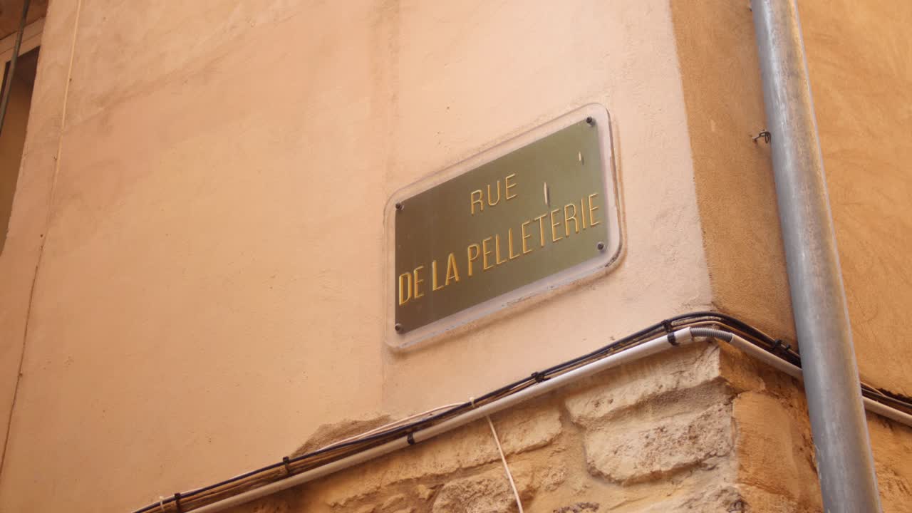Discover the charm of Montpellier's historic center through the lens of close-up street signage. Filmed in bright daylight, this capture highlights the city's unique architecture and culture