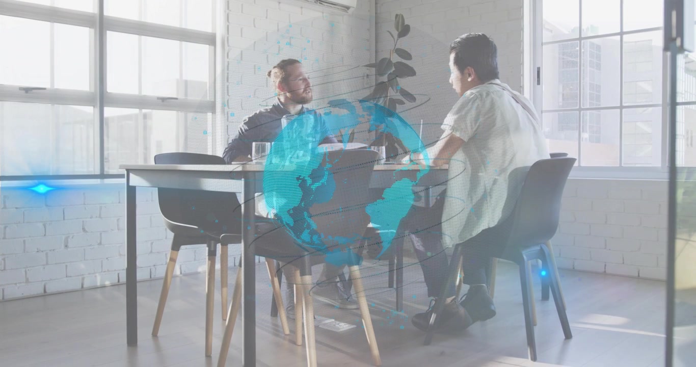 Dois homens trocando dados de negócios em uma mesa de madeira, com um gráfico de globo surgindo gradualmente, guiando a digitação e a tomada de notas.