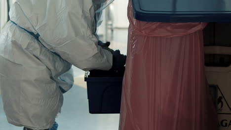 wring out a dirty cloth by the cleaner of the infectious diseases unit covid-19, protective clothing worn by personnel