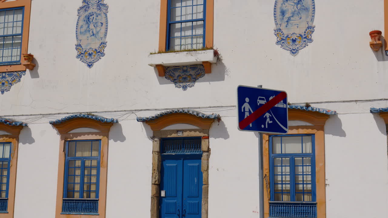 Traffic Sign Marking End Of Shared Street Zone In Front Of Colorful Building With Blue Door And Windows. static shot