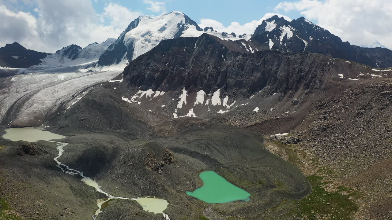키르기스스탄의 알라콜 호수와 빙하 주변의 넓은 공중 드론 샷