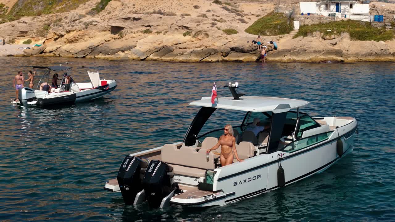 Blonde woman relaxing on a boat floating on the serene sea near Nice, France. A scene of luxury, summer vibes, and leisurely lifestyle, capturing the essence of a Mediterranean vacation.