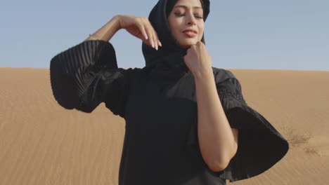 Mujer-Musulmana-Con-Vestido-Negro-Tradicional-Y-Hiyab-Posando-En-Un-Desierto-Ventoso-2
