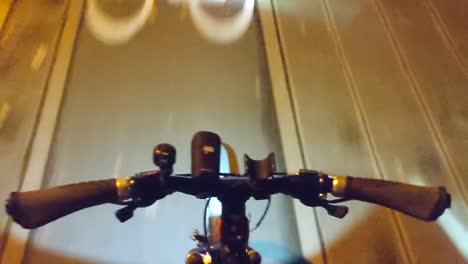 peron montando su bicicleta por el campo, la cámara baja hasta el punto de vista del manillar.