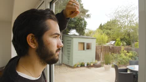 Male-looking-out-of-a-window-in-quarantine