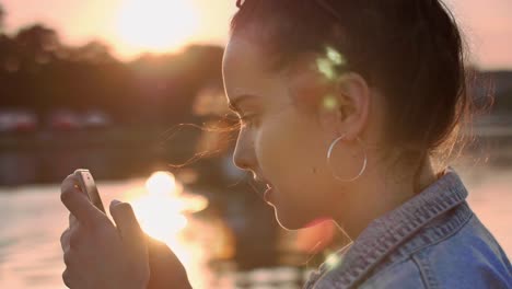 Girl-using-a-smart-phone-at-the-lake