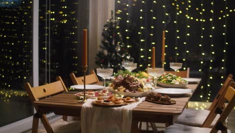 festive dinner with candles, dining table. celebrating new year, delicious dishes, cooked homemade food on plates. christmas party concept, family tradition.