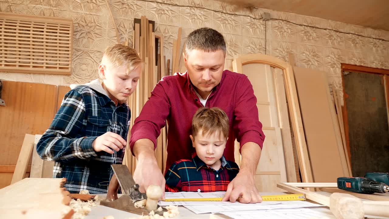 familia, carpintería, madera y concepto de la gente. el padre enseña a su hijo carpentería.