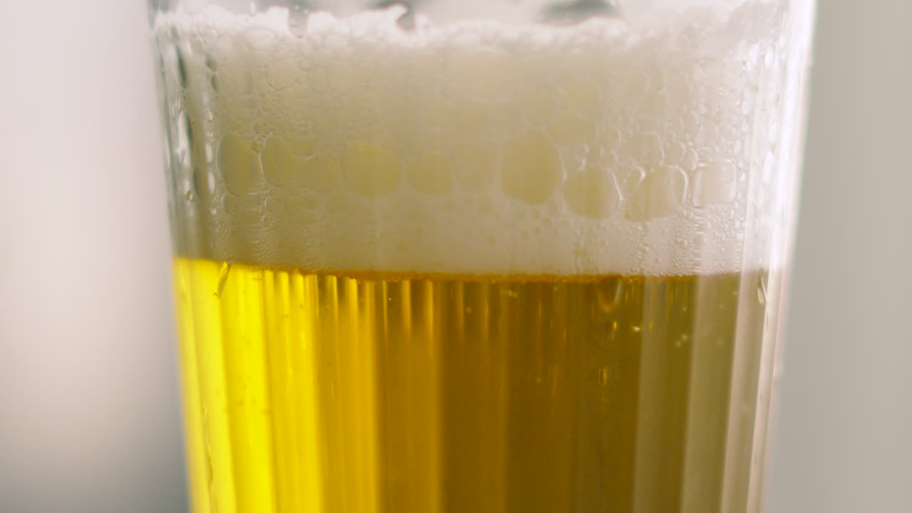 Freshly Poured Chilled Lager Beer as Camera Rises and Reveals Foam Top