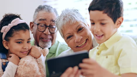 niños, teléfonos inteligentes y abuelos en el sofá para