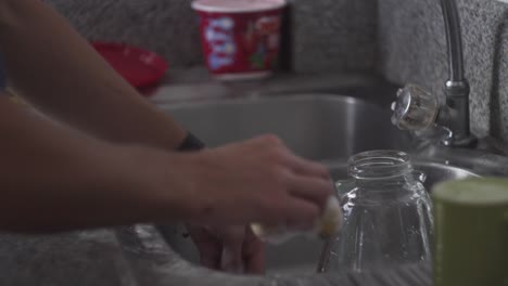 adult cleaning blender and its parts with soap and sponge - static shot