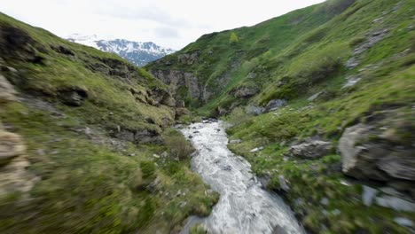 FPV-drone-flying-at-high-speed-over-rocky-surface-of-Mount-Cenis-and-lake-between-Italy-and-France