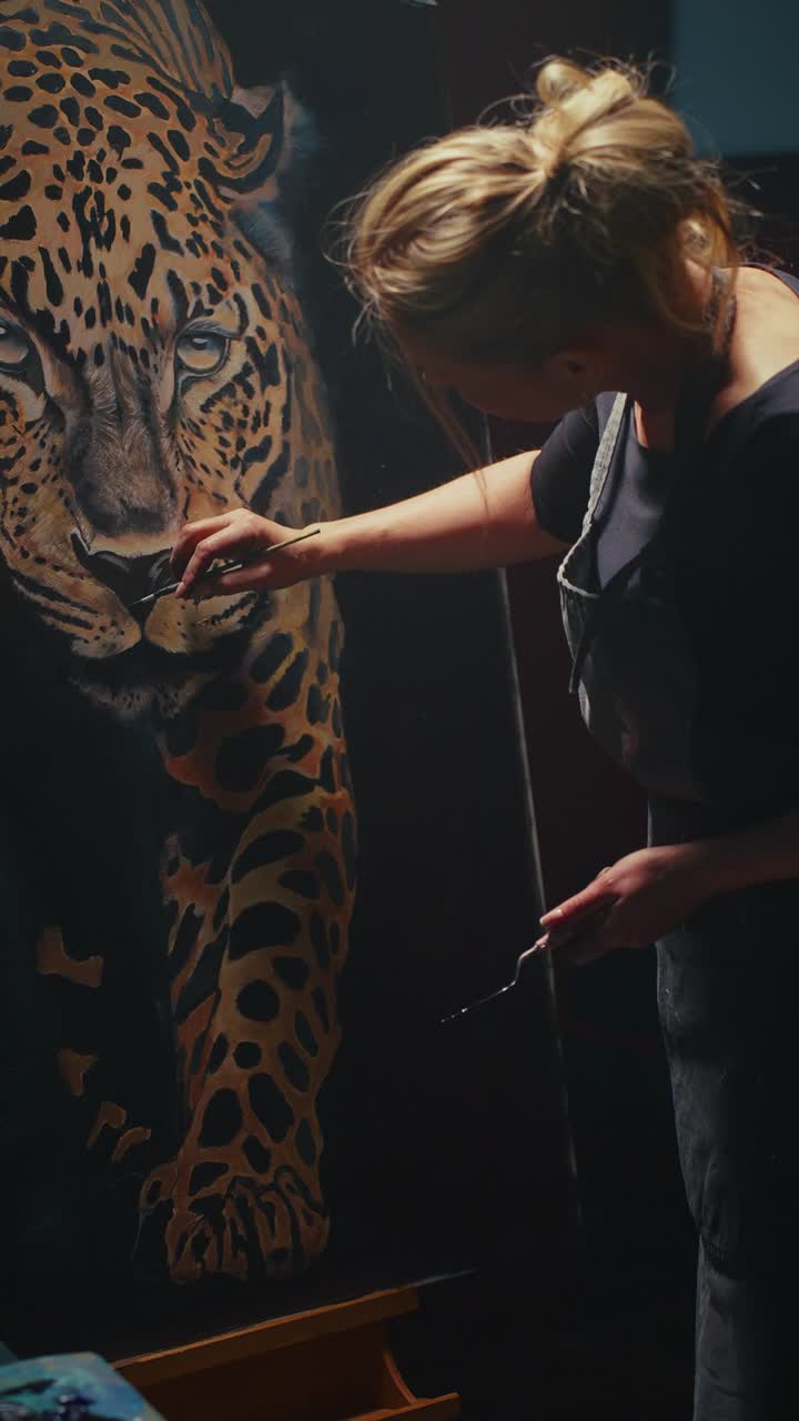 Woman painting a leopard in her art studio