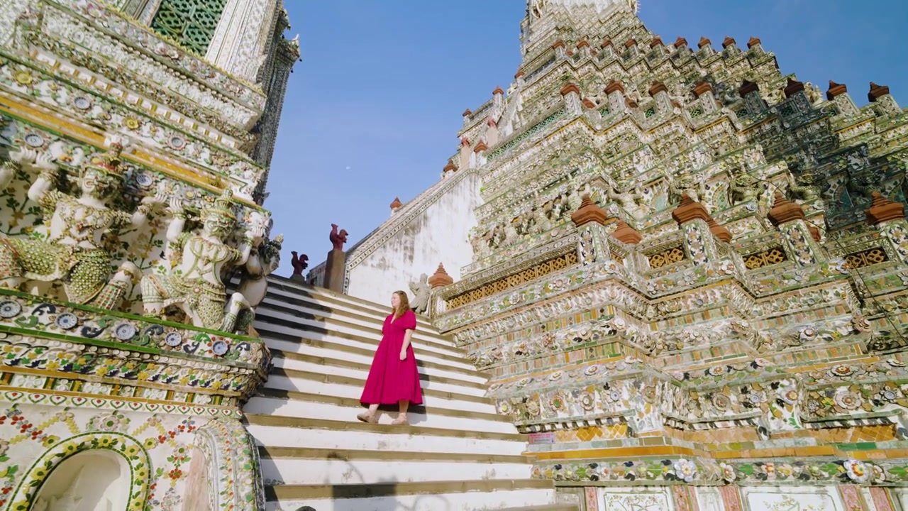 Turista donna con vestito rosso in visita al Tempio Wat Arun a Bangkok, Thailandia. Ripresa FPV rotante.