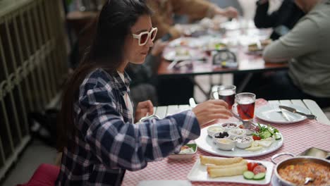 woman enjoying a turkish breakfast outdoors