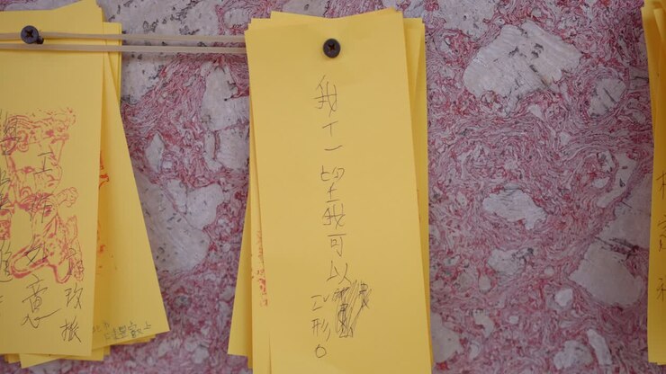Numerose preghiere scritte appese su foglietti colorati sulla parete del tempio di Tainan.