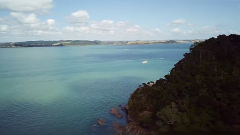 drone aéreo se eleva sobre el acantilado para revelar la bahía de waihihi en la bahía de las islas en un día de verano