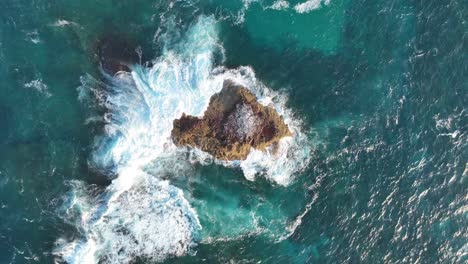 Top-down-descending-shot-of-small-rock-Island-off-coast-of-Stradbroke-Island