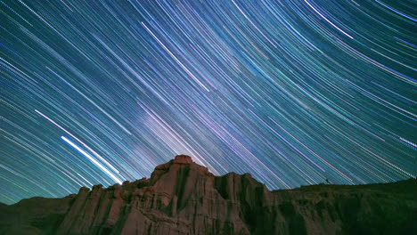 a stunning view of the milky way forming star trails above the cliffs of red rock canyon state park